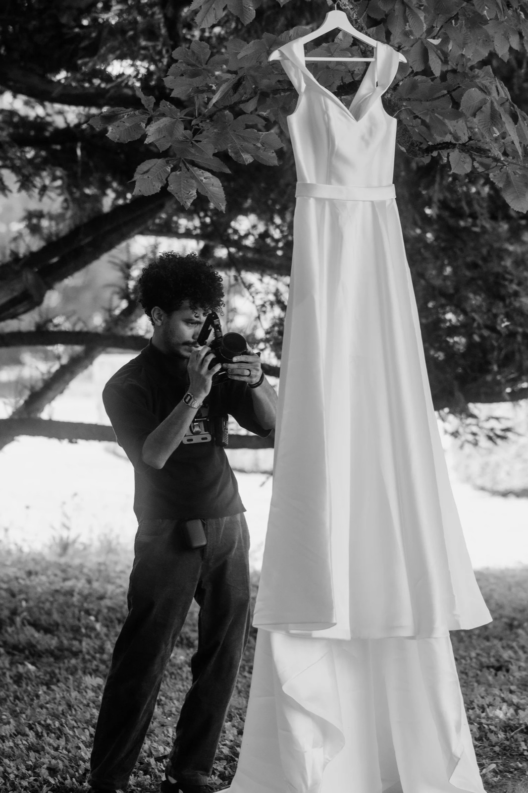 Israel do Nascimento fotografando um vestido de noiva pendurado numa árvore